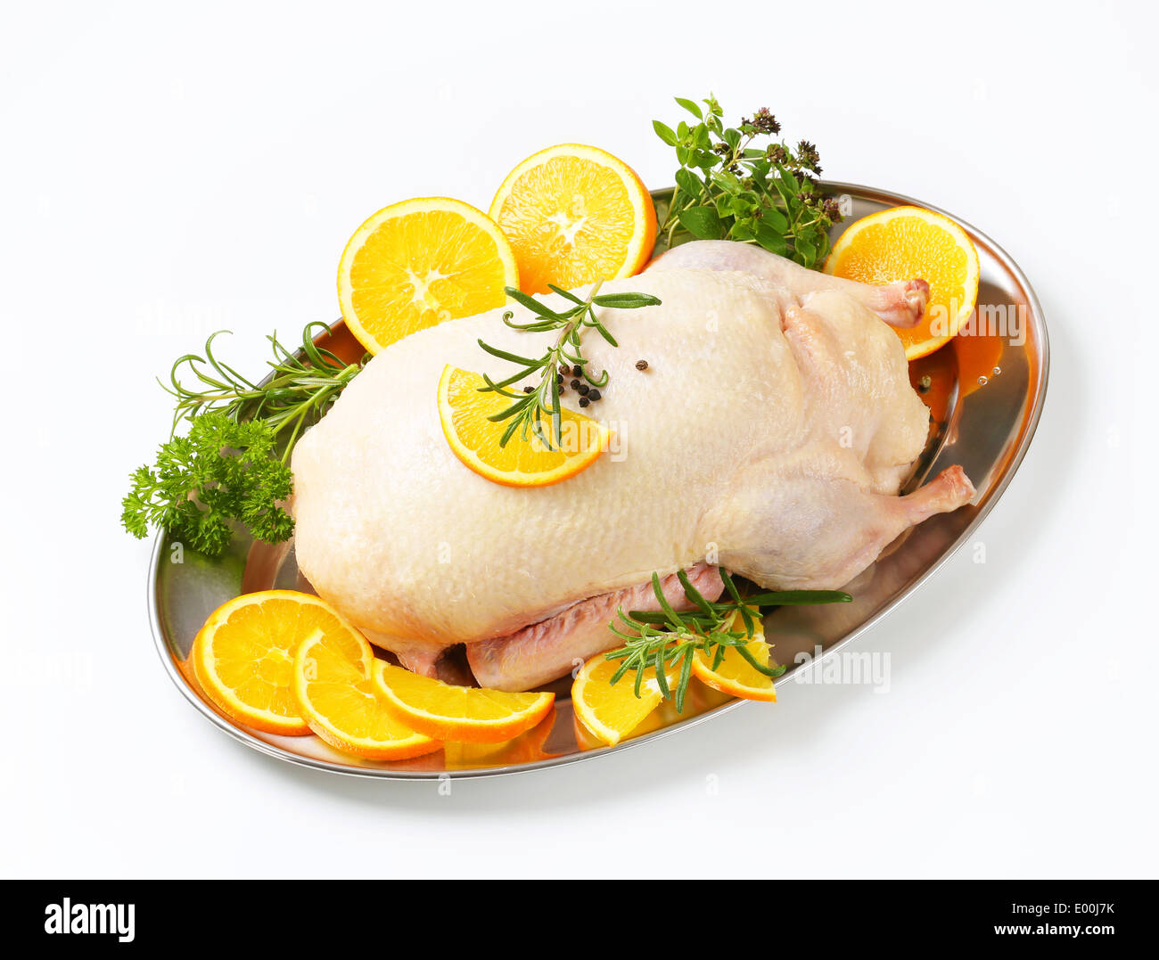 Materie di anatra con fettine di arancia e di erbe su un vassoio di metallo Foto Stock