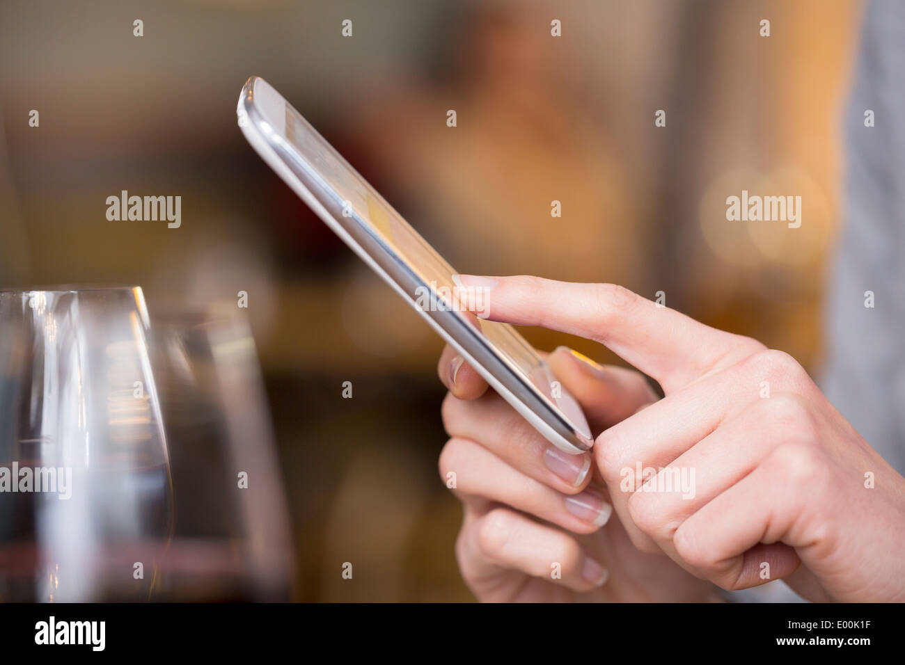 Femmina pub allo smartphone i messaggi di testo sms dita messgae pub e-mail Foto Stock