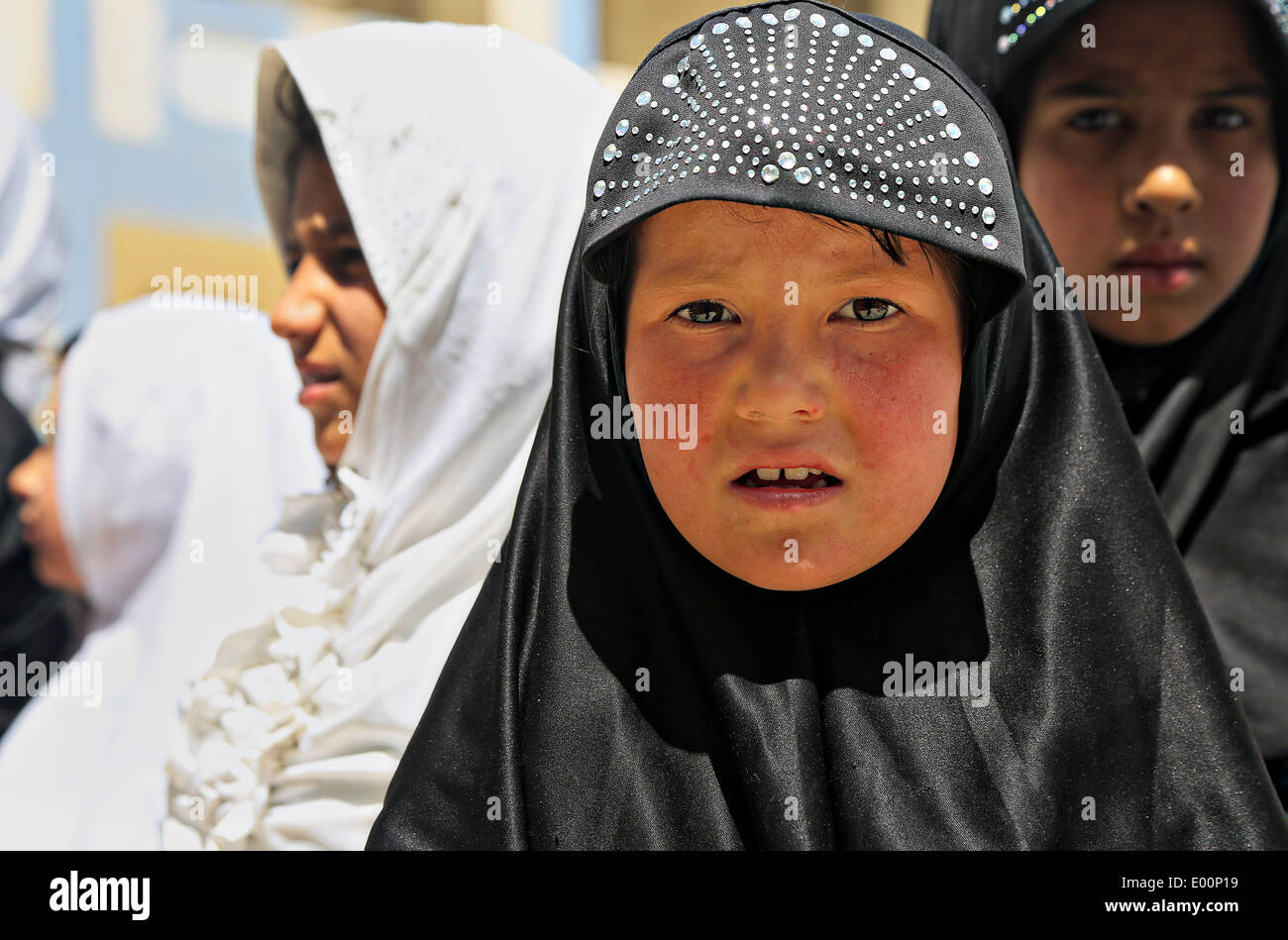 Una giovane ragazza afghana durante la distribuzione dell'aiuto umanitario presso una scuola Aprile 16, 2014 a Kandahar, provincia di Kandahar, Afghanistan. Foto Stock