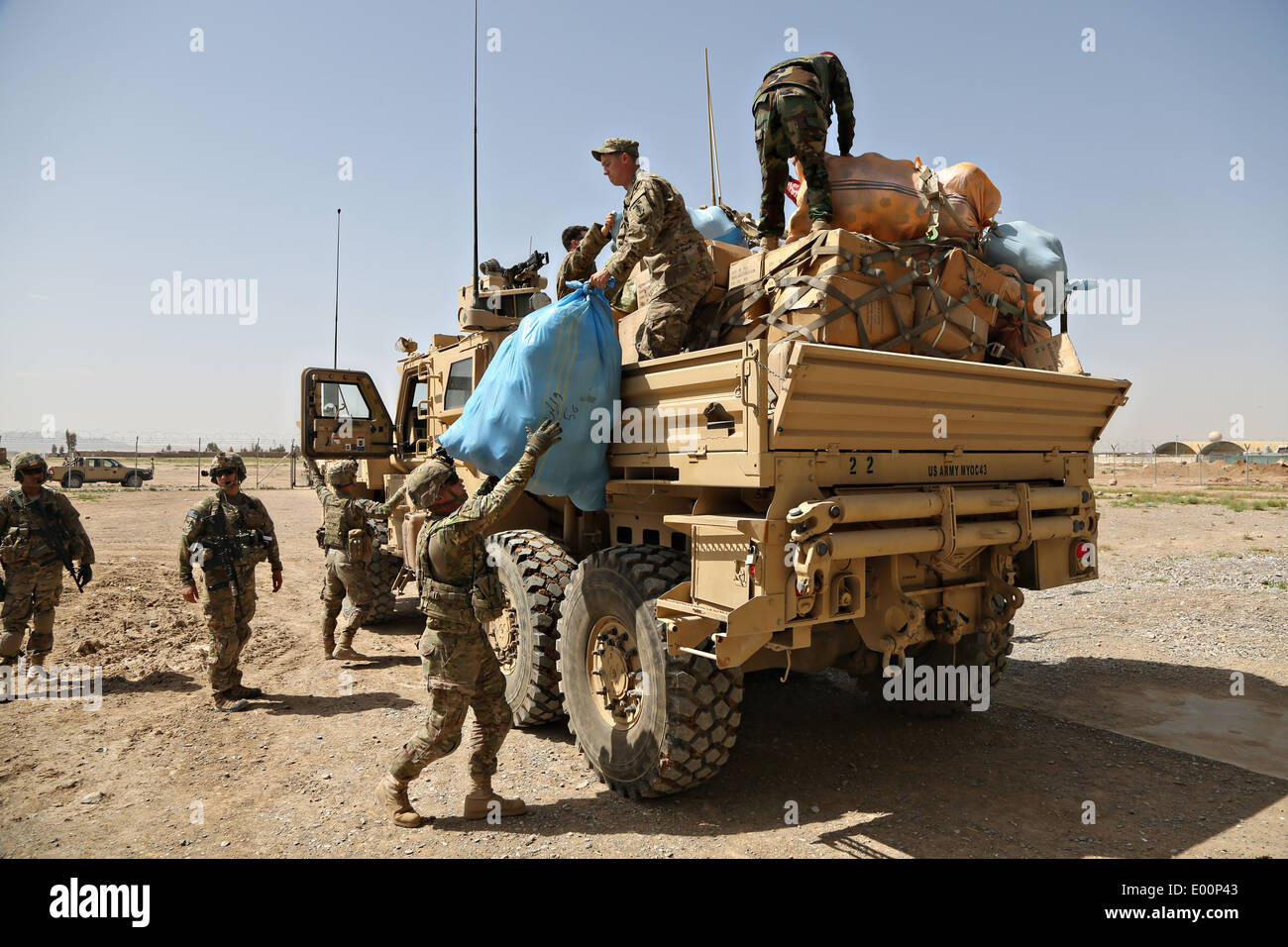 I soldati USA assegnato e l esercito nazionale afghano soldati scaricare la fornitura di aiuti umanitari in una scuola Aprile 16, 2014 a Kandahar, provincia di Kandahar, Afghanistan. Foto Stock