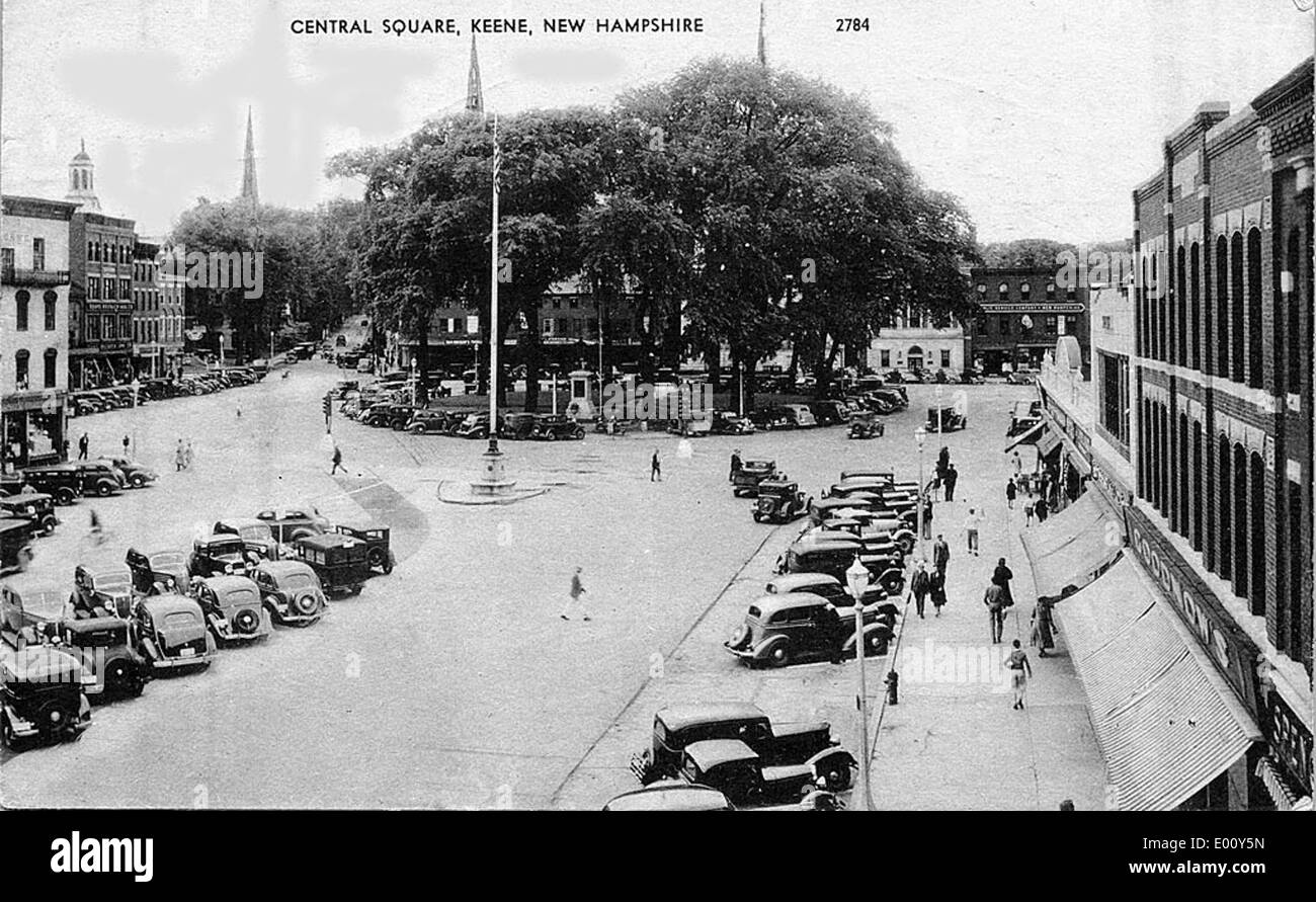 Questa immagine di Central Square a Keene, New Hampshire, mostra un vivace quartiere finanziario. Si possono vedere auto d'epoca che riflettono l'atmosfera della metà del XX secolo, mentre l'architettura circostante evidenzia l'area del centro di Keene. Foto Stock