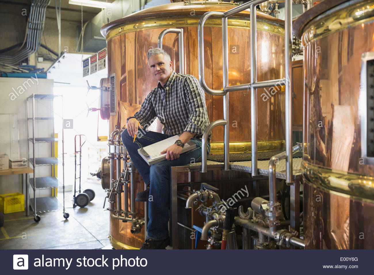 Ritratto di brew master seduta in alambicchi di rame Foto Stock