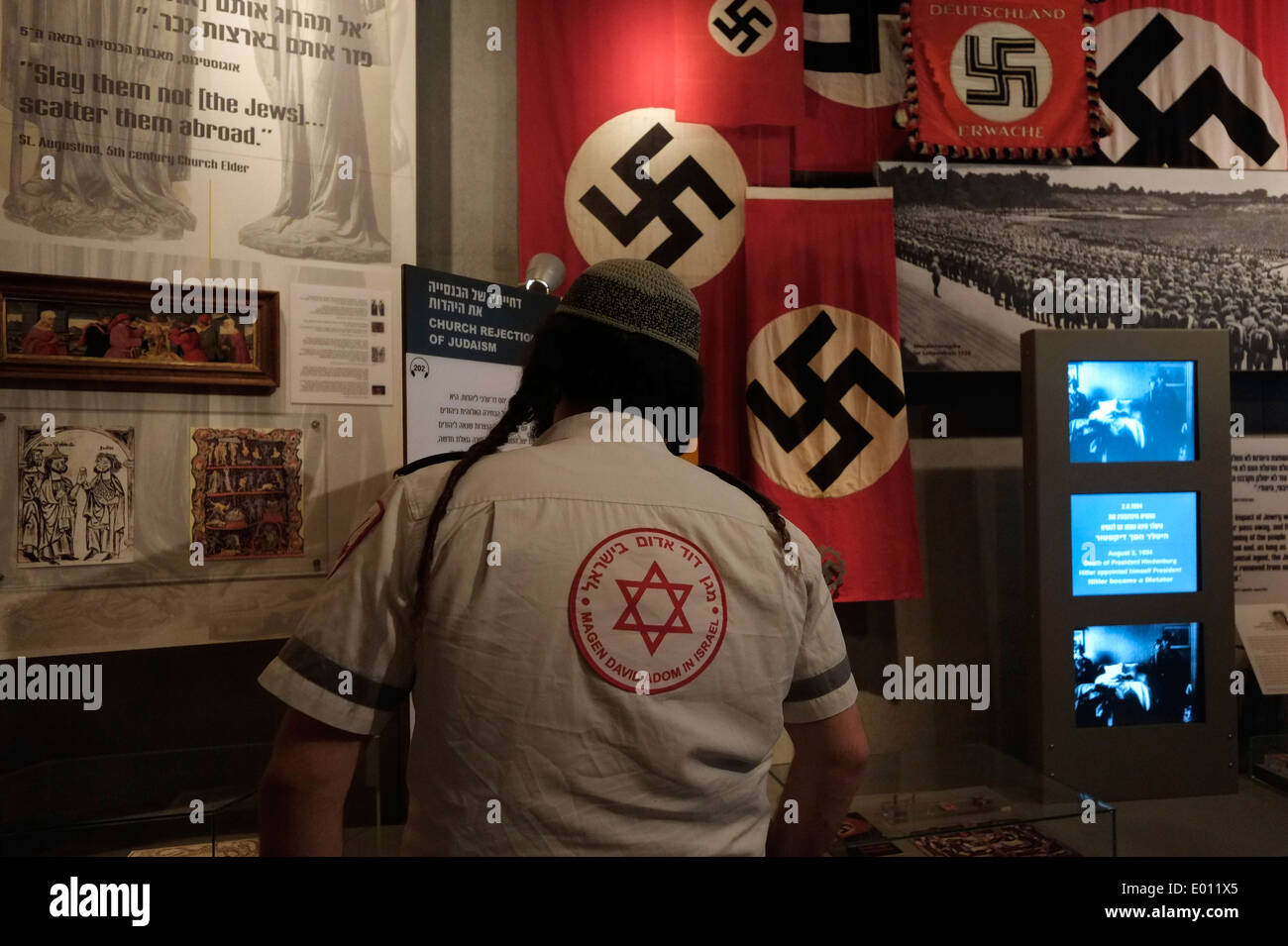 Un ebreo religioso guarda svastiche naziste esposte a Yad Vashem, il World Holocaust Remembrance Center, a Gerusalemme, Israele, per commemorare i 6 milioni di vittime ebree uccise dai nazisti durante la seconda guerra mondiale Foto Stock