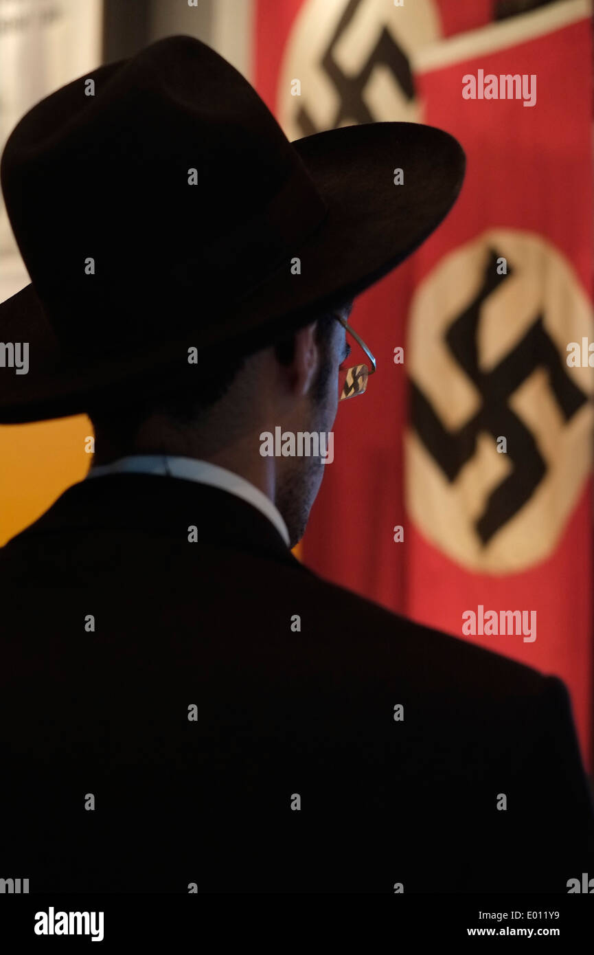 Un ebreo haredi guarda una mostra di svastiche naziste a Yad Vashem, il World Holocaust Remembrance Center, a Gerusalemme, in Israele, per commemorare i 6 milioni di vittime ebree uccise dai nazisti durante la seconda guerra mondiale Foto Stock