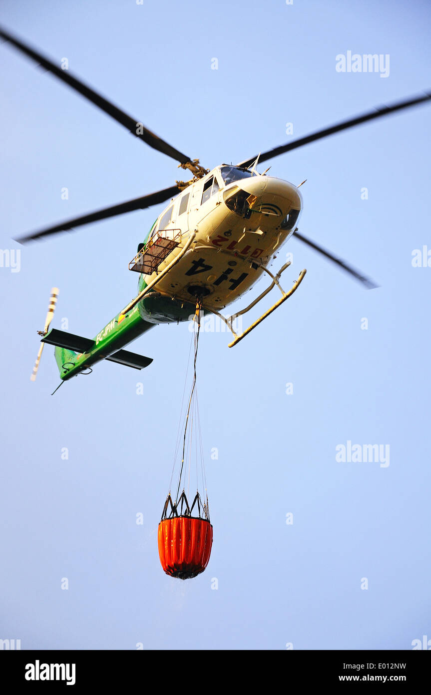 Bell 412 registrazione CE-IPM portando acqua per la lotta antincendio, Cabopino Golf in Andalusia. Foto Stock