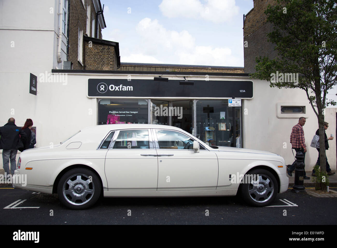 Rolls Royce auto parcheggiate al di fuori di una carità Oxfam shop in Chelsea. Un chiaro caso di ricchezza si dividono in Londra, Regno Unito. Foto Stock