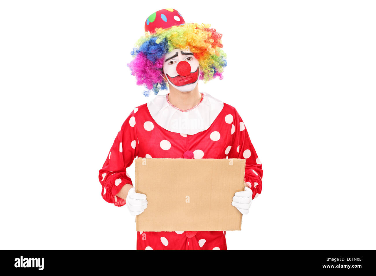 Triste clown maschio tenendo un vuoto segno di cartone Foto Stock