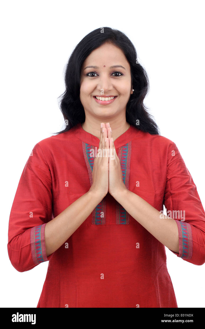 Sorridente giovane donna saluto "Namasthe' contro uno sfondo bianco Foto Stock