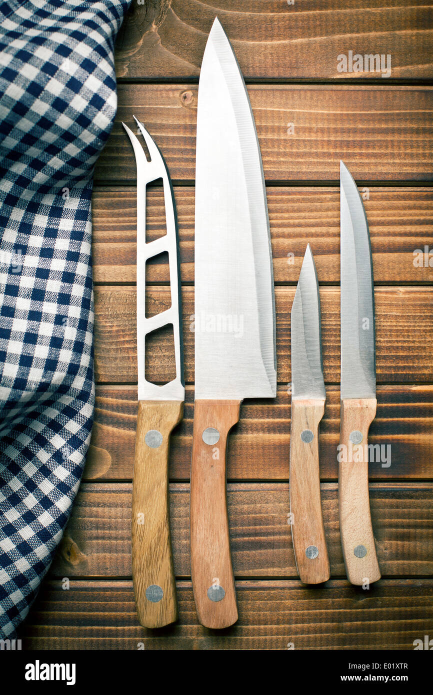 Set di coltelli da cucina sul vecchio tavolo in legno Foto Stock