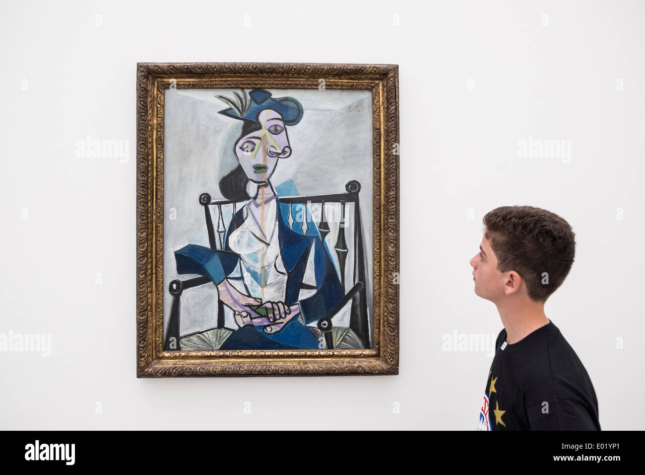 Ragazzo che guarda alla pittura di Pablo Picasso ' Sitzende Frau, 1941' alla Pinacoteca Museum di Monaco di Baviera Germania Foto Stock