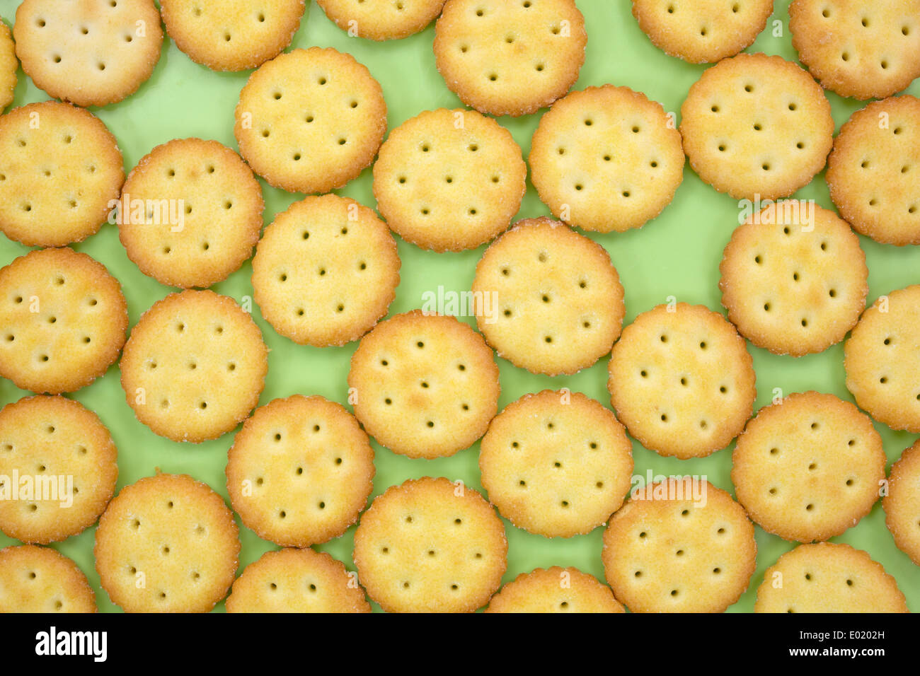 Chiudere la vista di un gruppo di piccoli snack crackers su una piastra verde. Foto Stock