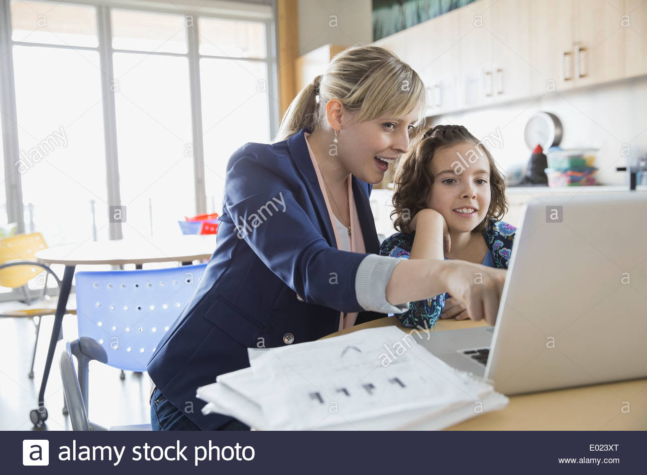 School girl e maestro utilizzando laptop in aula Foto Stock