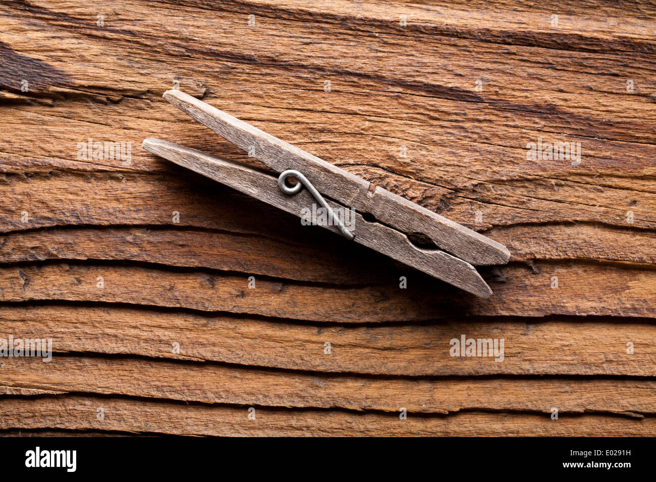 Una molletta da bucato su una notte a grana grossa sullo sfondo di legno Foto Stock