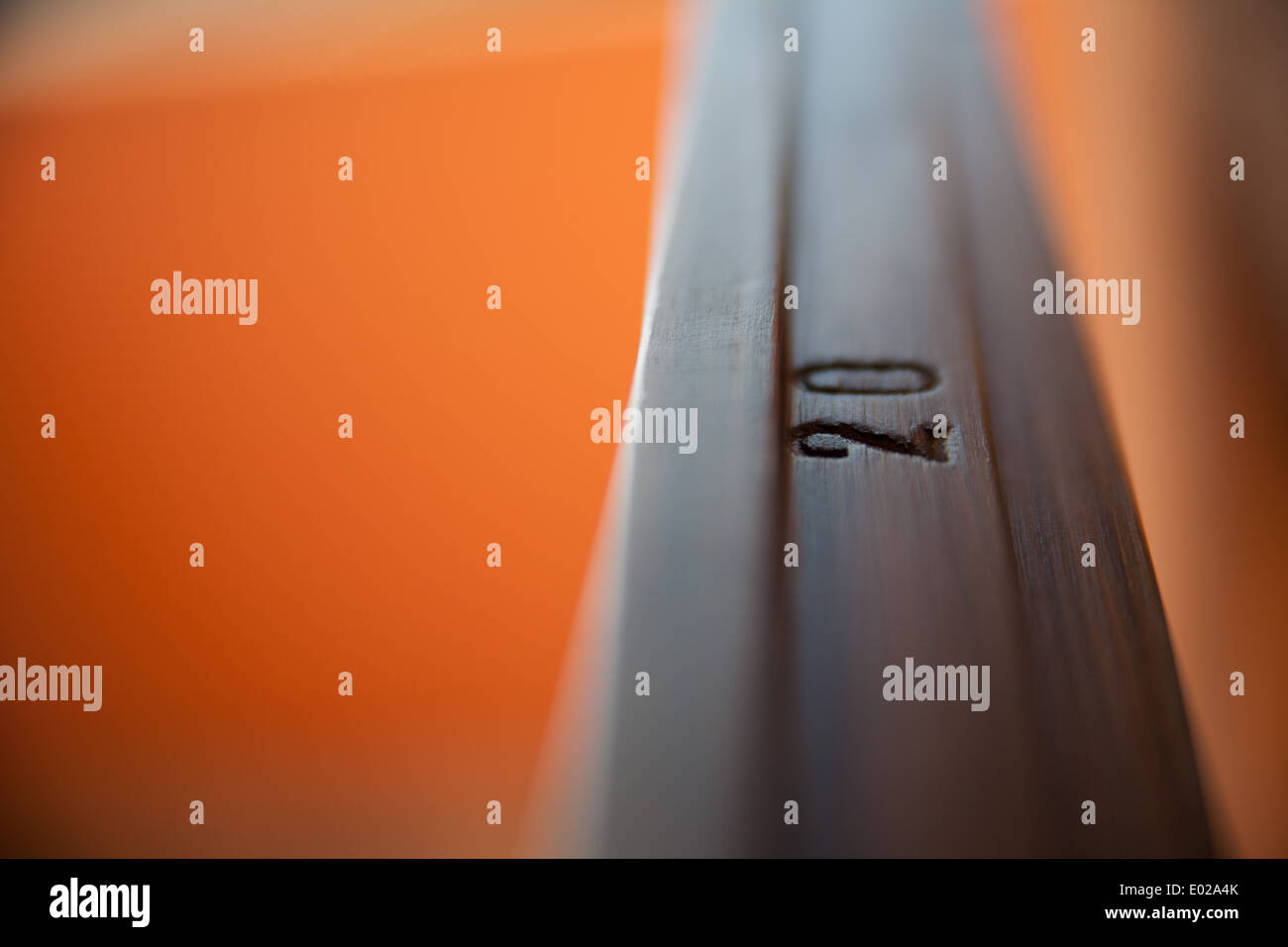 Dettaglio di un 20 su un lucido infisso in legno su uno sfondo arancione e bokeh di fondo Foto Stock