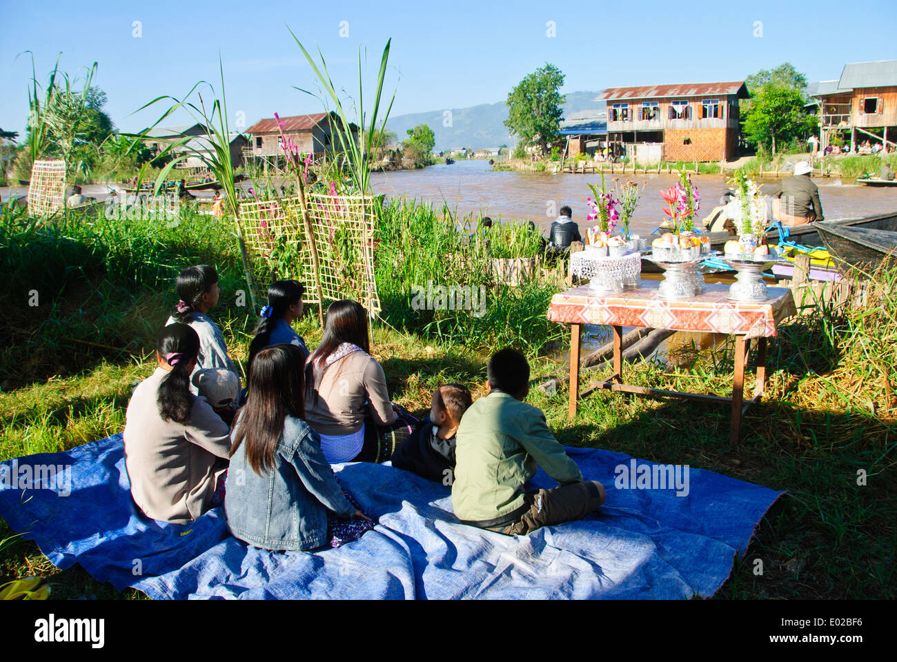 Gli abitanti dei villaggi locali di attesa con le loro offerte per il Royal Barge acqua processione, Lago Inle Festival Foto Stock