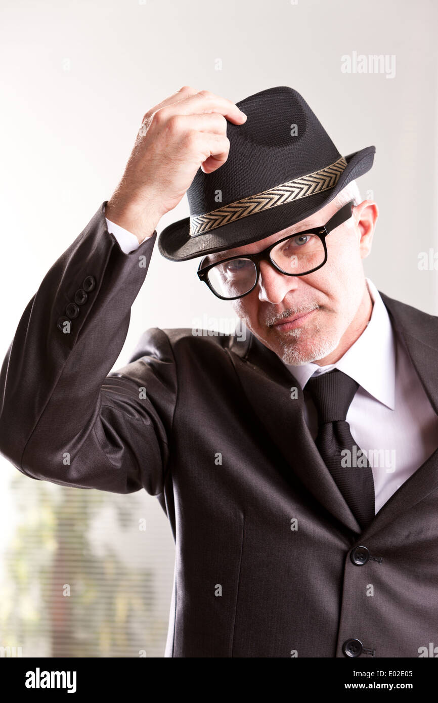 Un stile anni cinquanta retrò uomo d affari in aumento il suo cappello a salutare voi Foto Stock