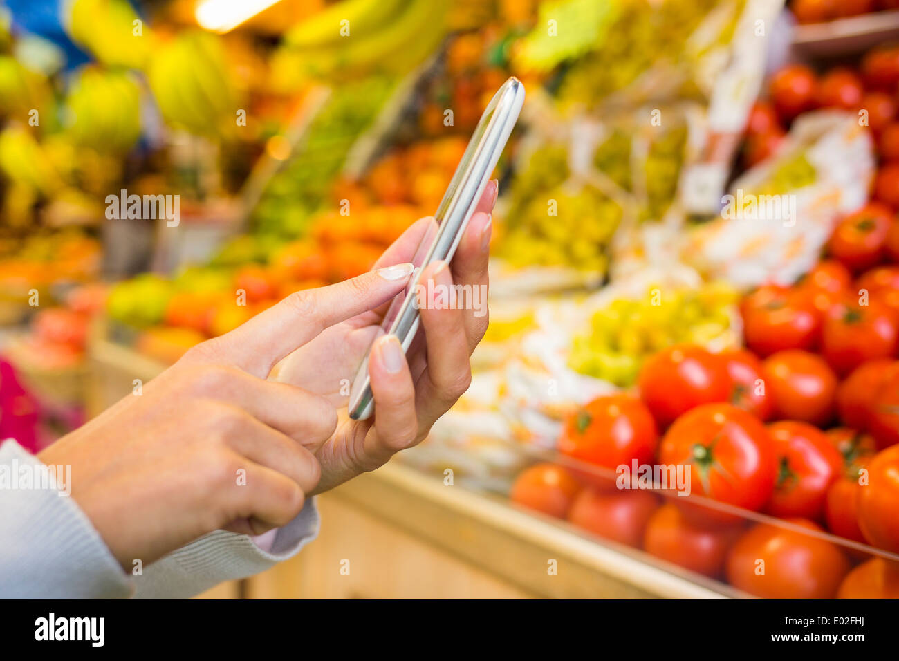 Vicino femmina telefoni cellulari negozio a mano Foto Stock