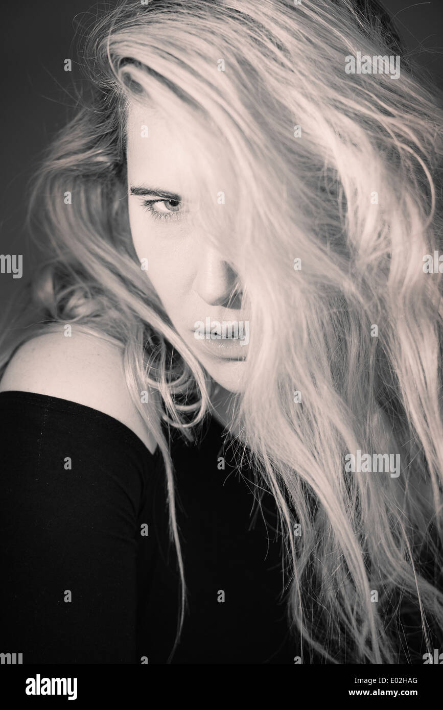Giovane bella donna bionda con i capelli lunghi. Mostra l'espressione di raffreddare atteggiamento e la sua personalità. Foto Stock