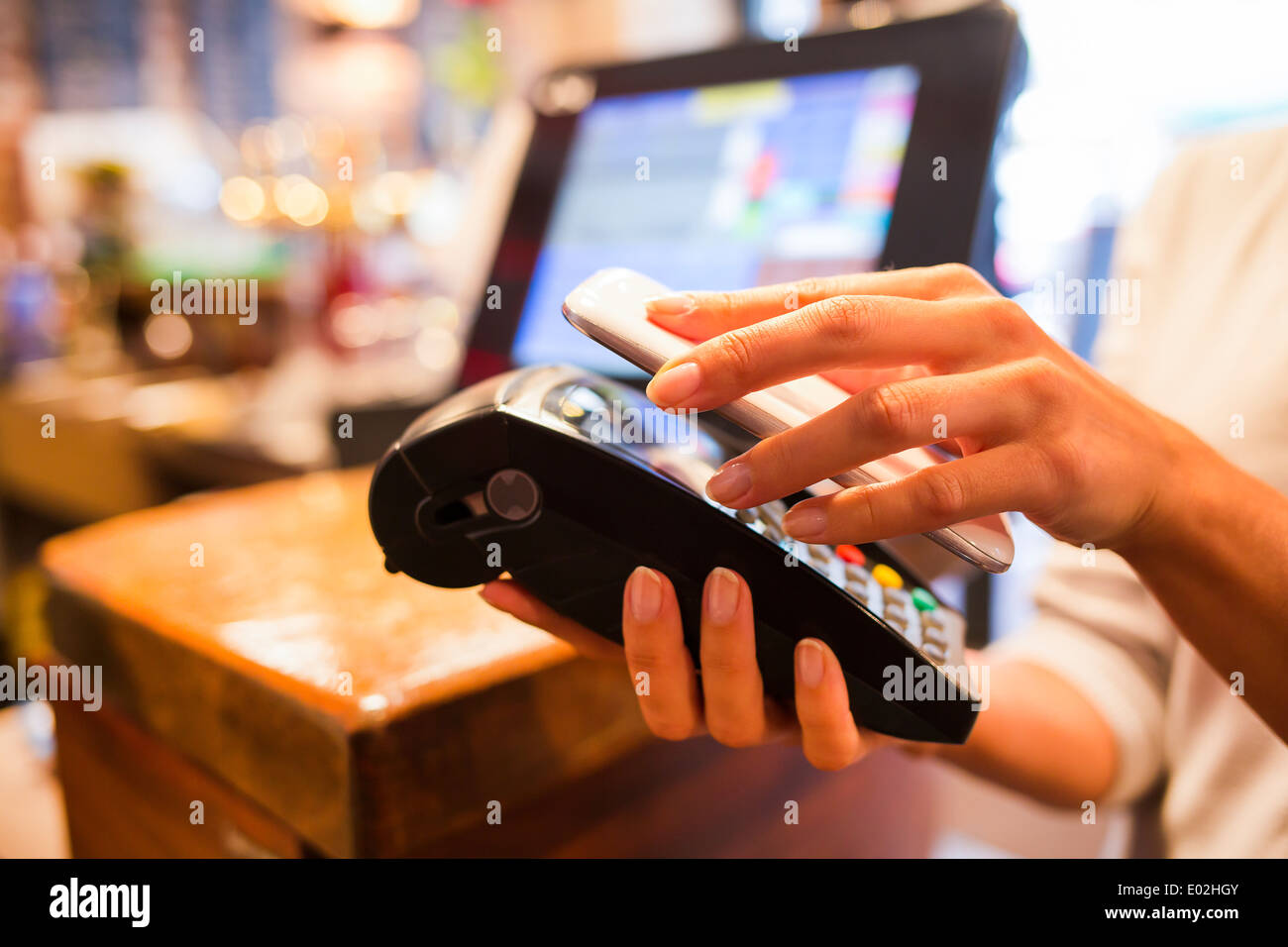 Femmina pagamento elettronico close-up cell phone shop mano lettore elettronico Foto Stock