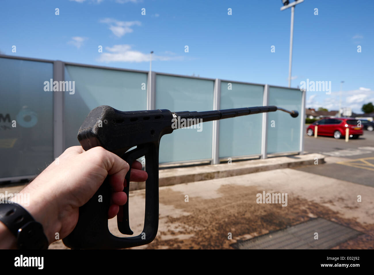 Uomo con stazione di riempimento benzina autolavaggio manuale lancia l'Irlanda del nord Foto Stock