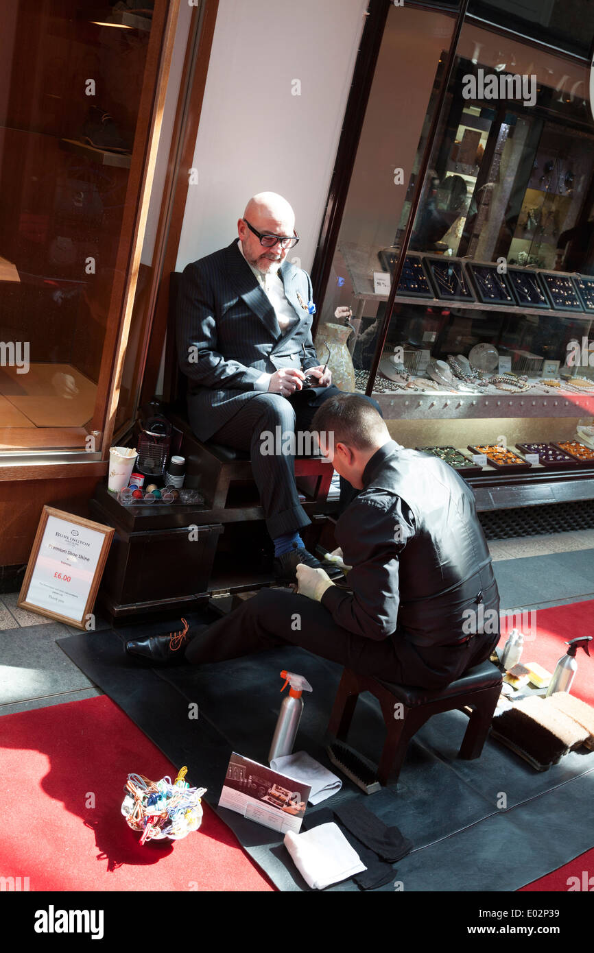 Lustrascarpe uomo i clienti di lucidatura scarpe in Burlington Arcade. Foto Stock