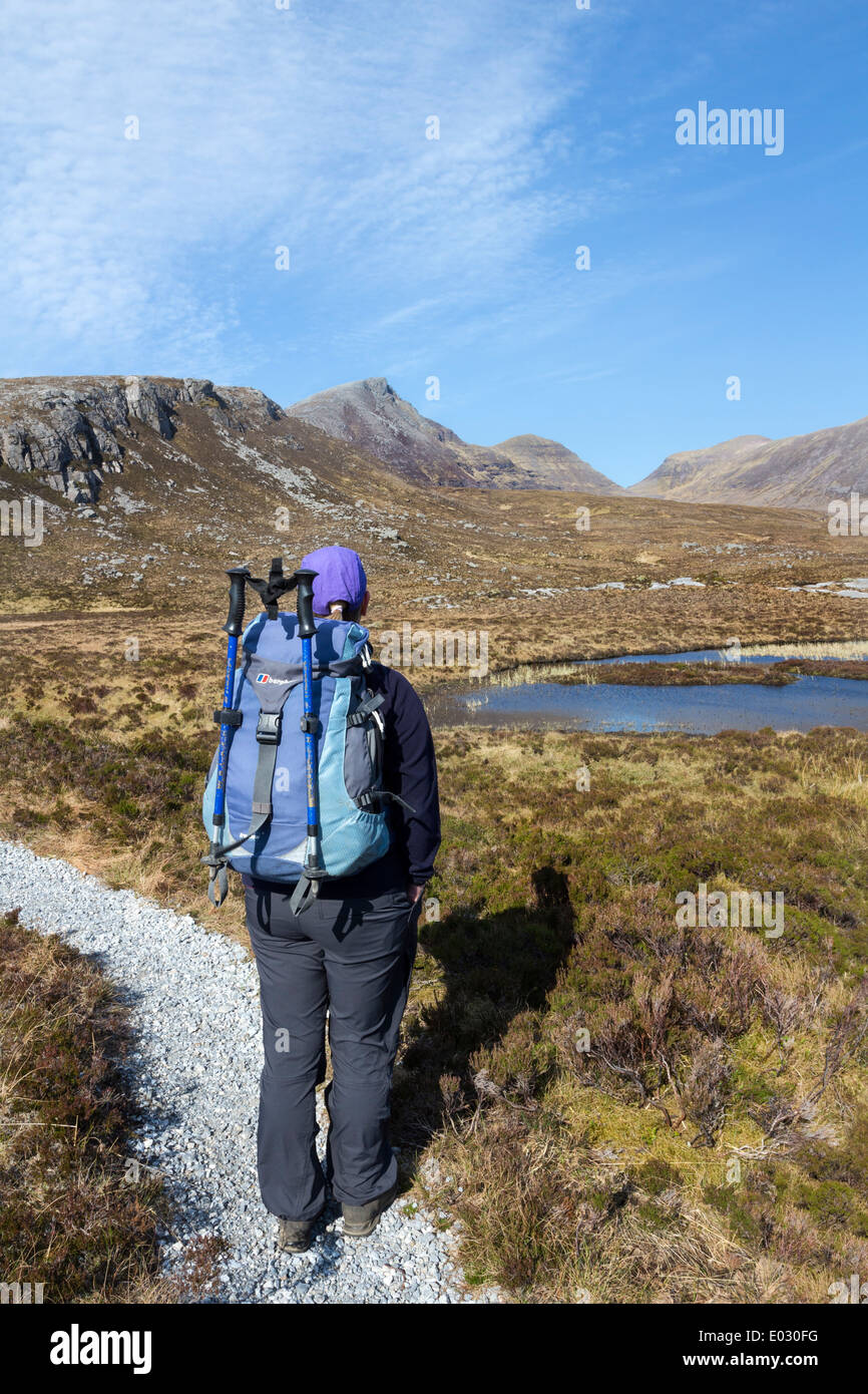 Walker godendo la vista verso la montagna Quinag Assynt settentrionale della Scozia UK Foto Stock