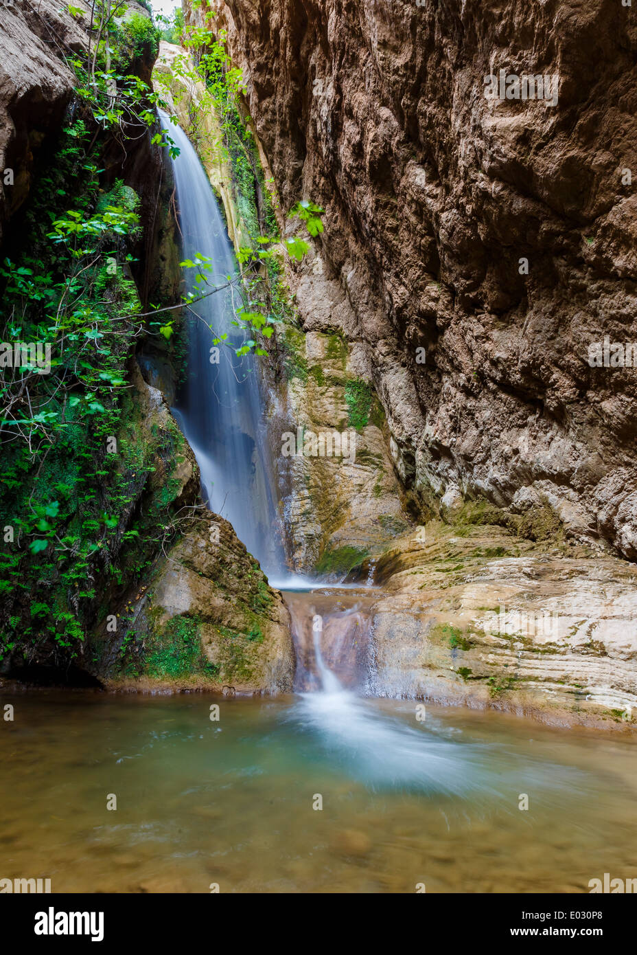 Una piccola cascata profonde nella foresta pluviale, girato in una lunga esposizione Foto Stock