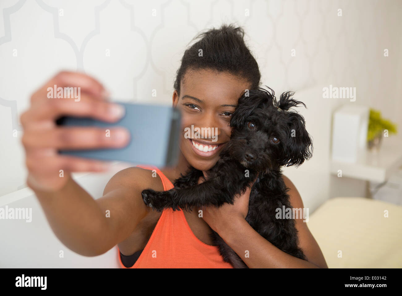 Una giovane ragazza tenendo un selfy del suo piccolo cane e se stessa. Foto Stock