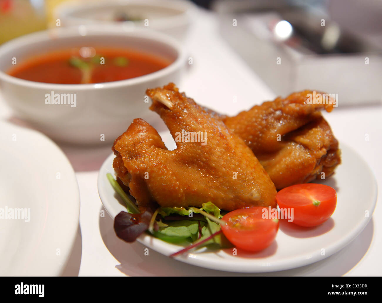 Ali di pollo su una piastra e la minestra in un cafe Foto Stock
