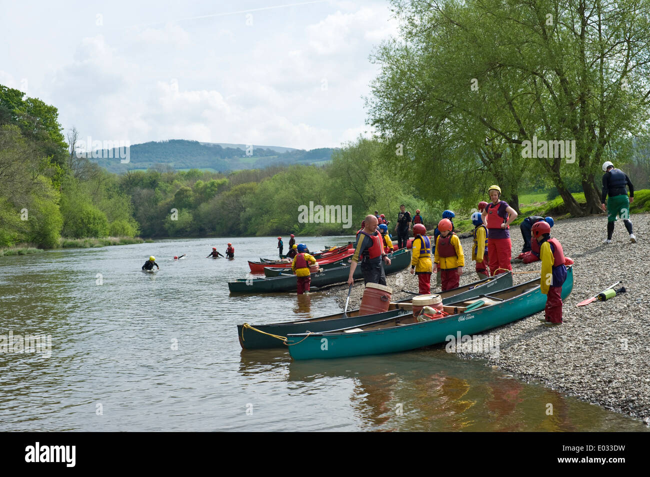 I gruppi di alunni su diretto verso l'esterno spedizione in canoa sul fiume Wye a Warren Hay-on-Wye Powys Wales UK Foto Stock