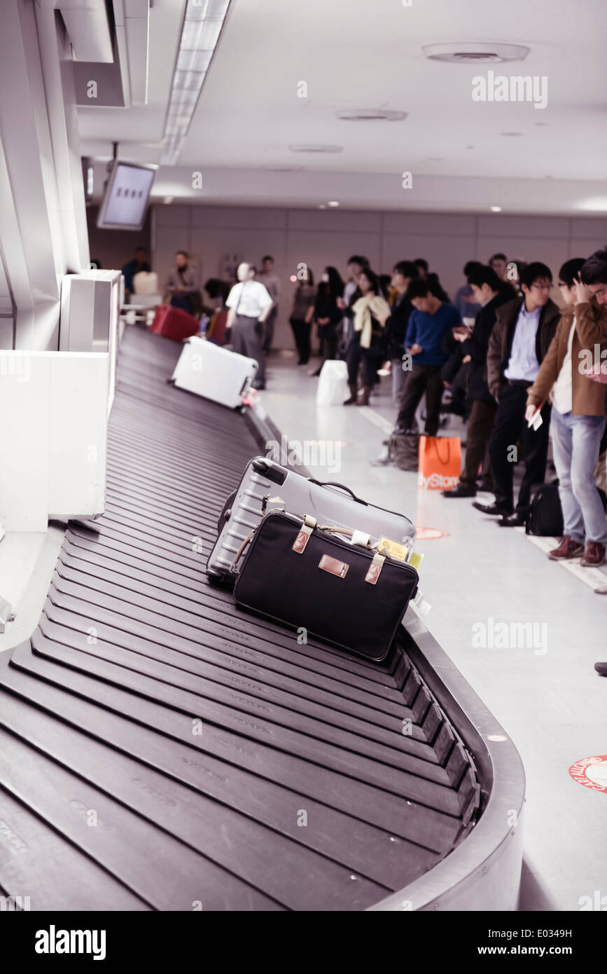 Persone in attesa per i loro bagagli all'Aeroporto Internazionale Narita reclamo bagagli trasportatore a giostra, Giappone Foto Stock