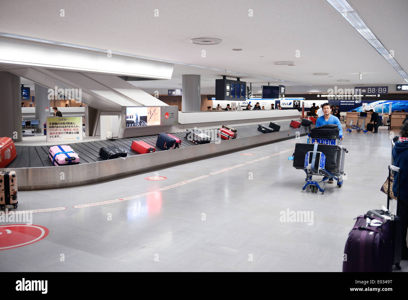 Persone che rivendicano i bagagli all'Aeroporto Internazionale Narita bagaglio trasportatore a giostra, Giappone Foto Stock