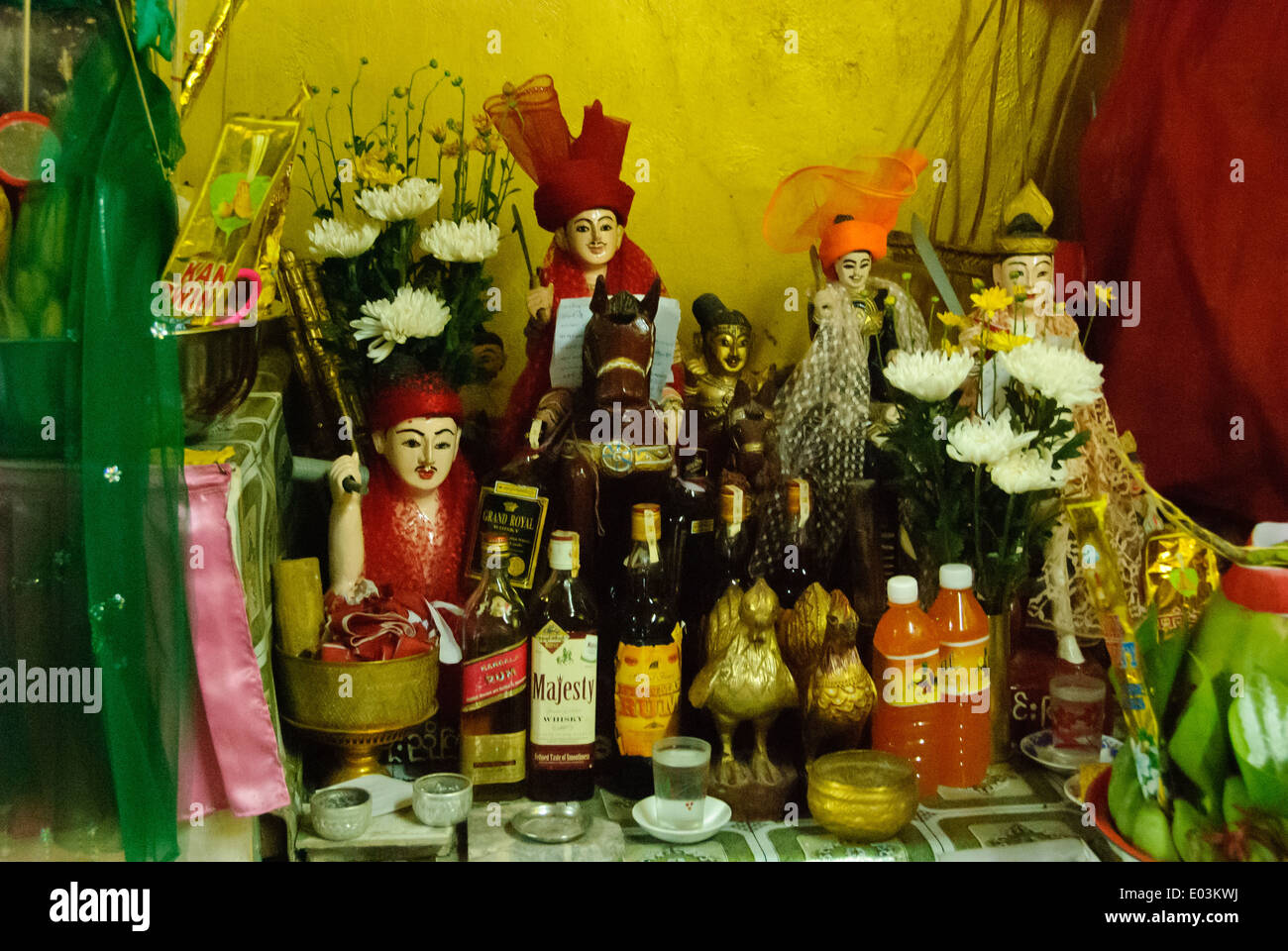Statue di nat, alcolici e le offerte in un santuario. Foto Stock
