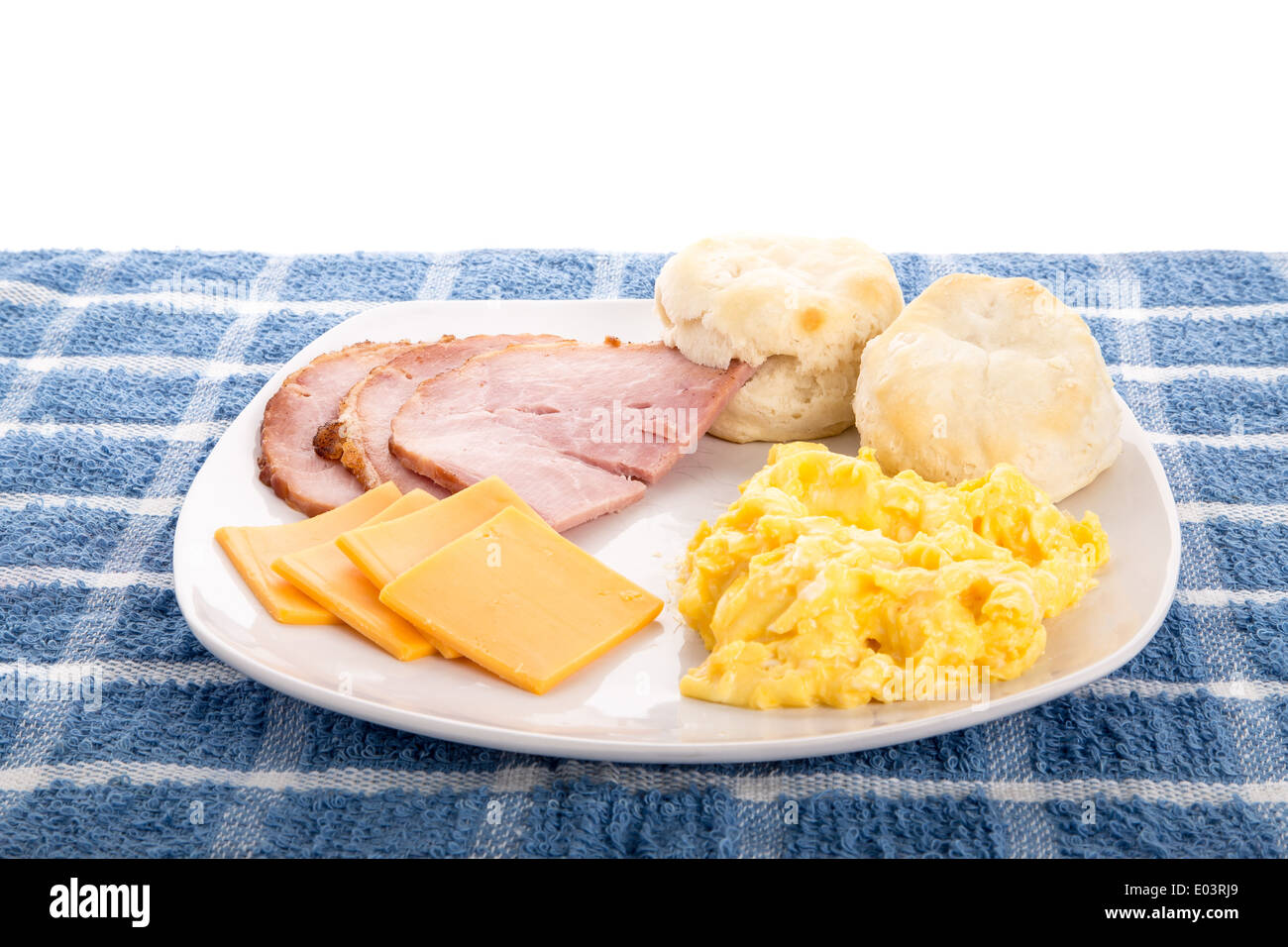 Un caldo, paese colazione a base di uova strapazzate, prosciutto a fette, fresche, biscotti caldi e formaggio a fette Foto Stock