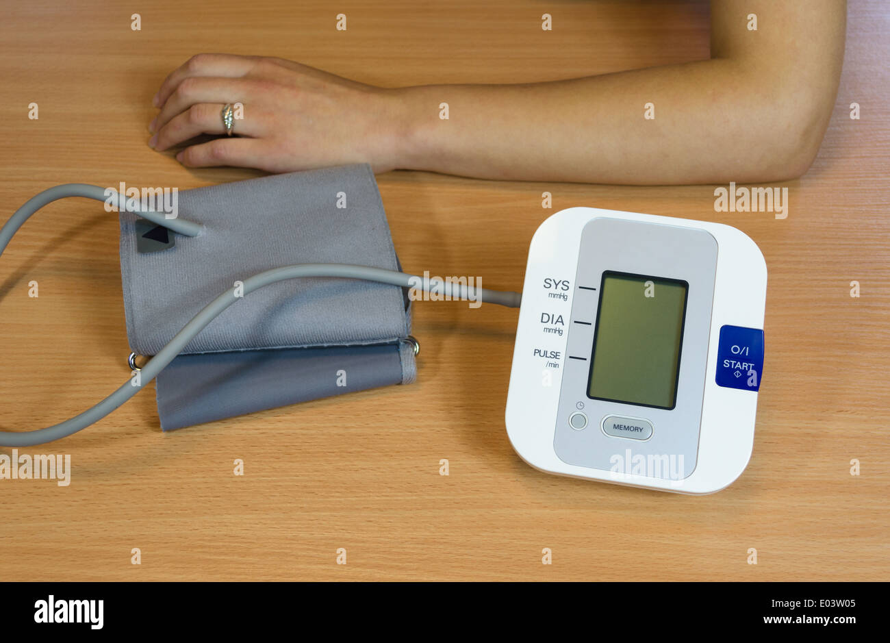 Mani femminili e digitale moderna misurazione pressione sanguigna attrezzatura sulla tabella Foto Stock