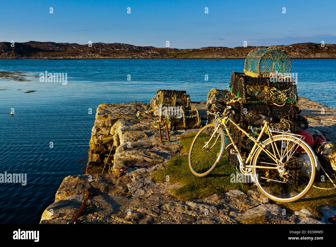 Il porto di Arinagour sull'Isola di Coll Ebridi Interne Argyll and Bute Scozia UK con la bici in appoggio contro gli attrezzi da pesca Foto Stock