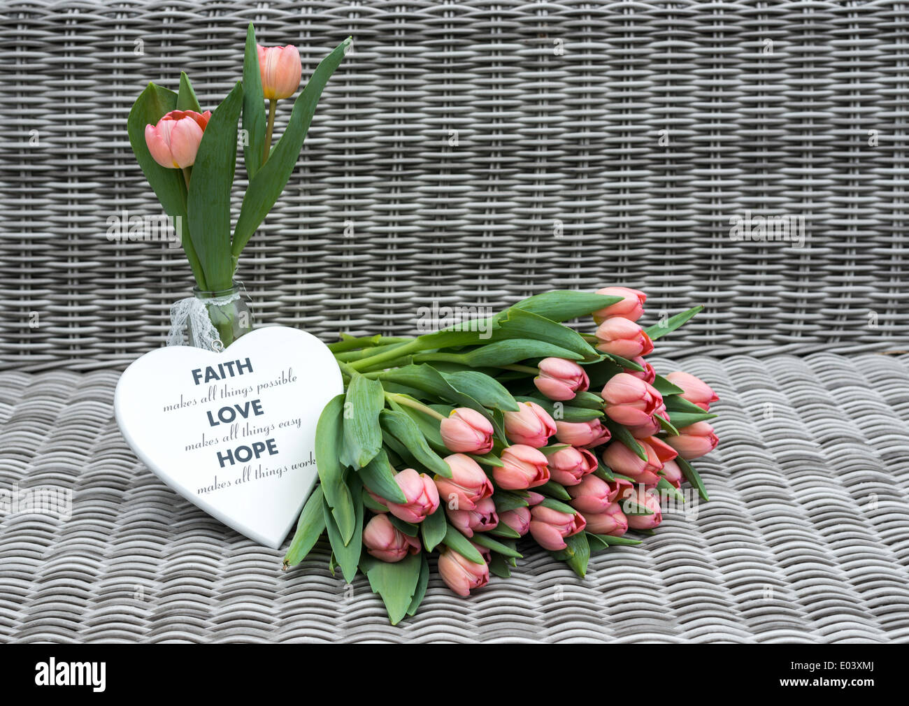 Vaso con rosa tulip fiori e forme di cuore per la festa della mamma su sfondo di bambù Foto Stock