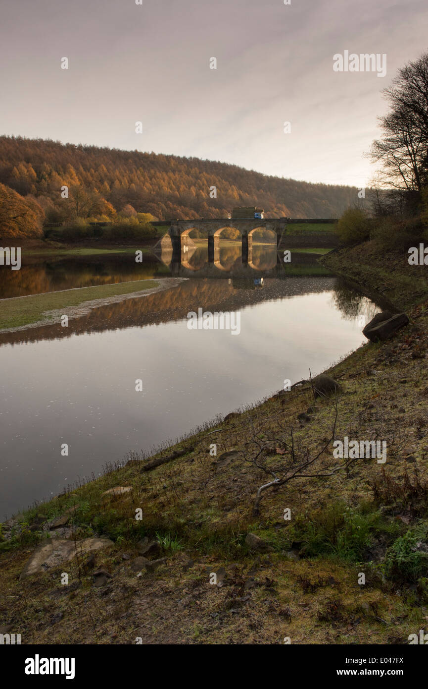 Vista panoramica del soleggiato archi del ponte stradale & woodland, riflesso in acque calme di Lindley serbatoio di legno - vicino a Otley, North Yorkshire, Inghilterra, Regno Unito. Foto Stock