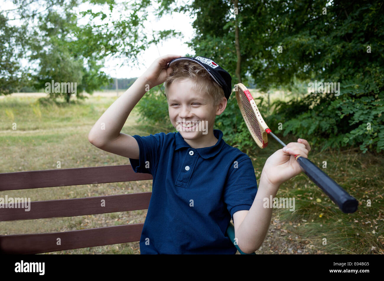 Ragazzo età 10 tenendo un badminton racchetta e avente una buona risata sopra il suo ultimo gioco. Zawady Polonia centrale Foto Stock