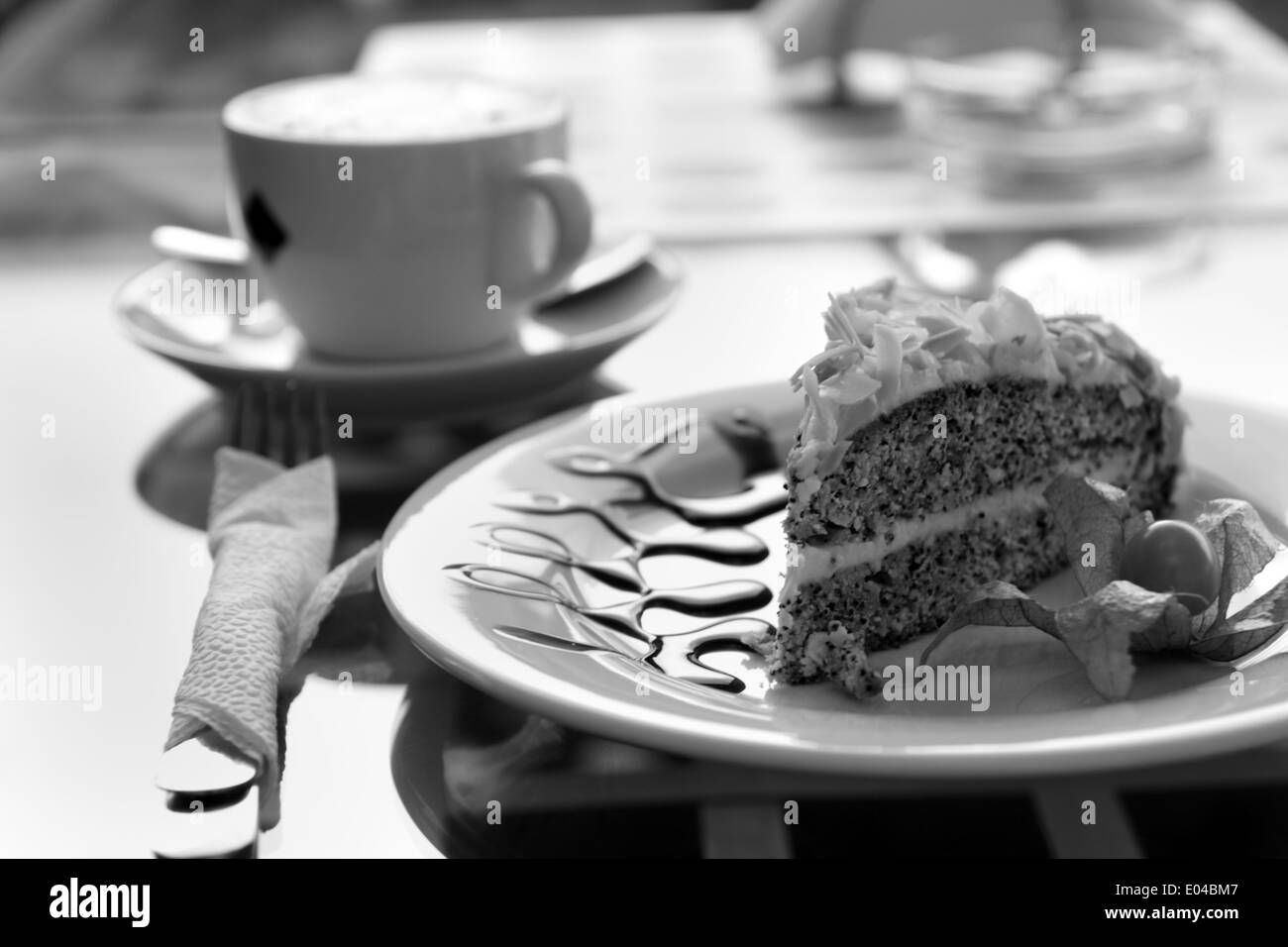 Il Cappuccino e semi di papavero torta sul tavolo del bar all'aperto al mattino soleggiato. Foto Stock