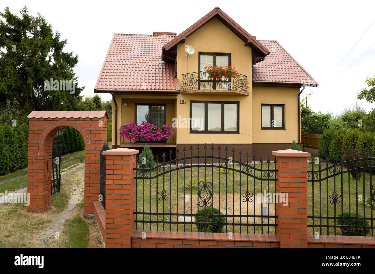 Moderna casa polacca con ferro battuto recinto con pilastri in mattoni e arch. Rzeczyca Polonia centrale Foto Stock