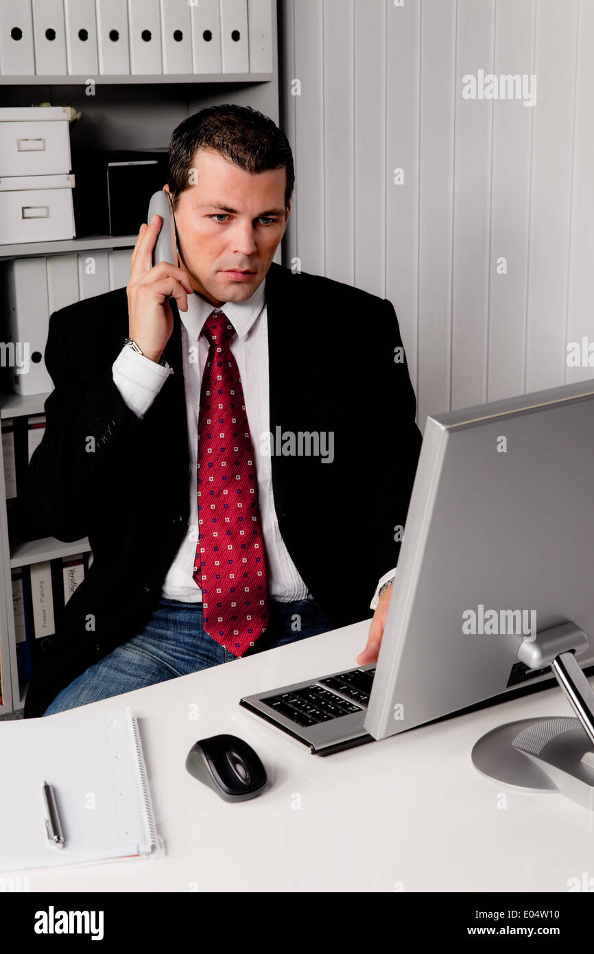 Giovane imprenditore in ufficio con il telefono, Junger Geschaeftsmann Buero im mit Telefon Foto Stock