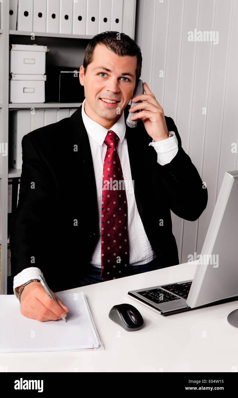 Giovane imprenditore in ufficio con il telefono, Junger Geschaeftsmann Buero im mit Telefon Foto Stock