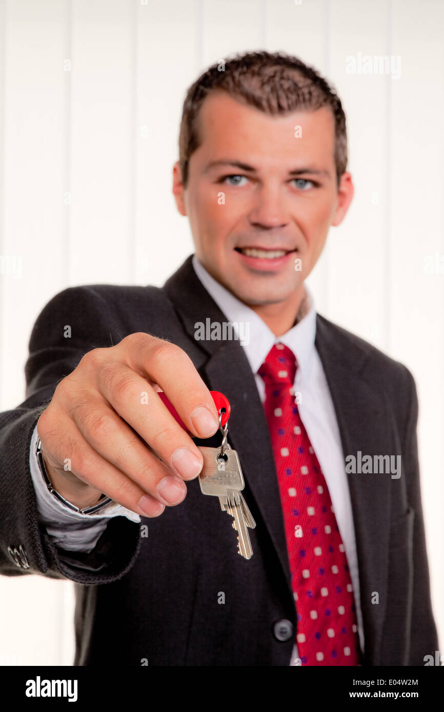 Di successo veramente mediatori immobiliari con la chiave di un piatto, Erfolgreicher Immobilien Makler Schluessel mit einer Wohnung Foto Stock