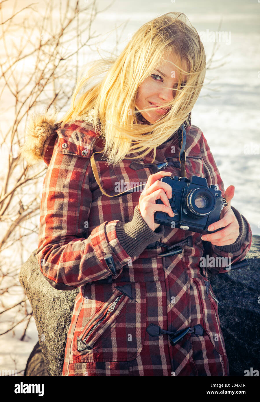 Giovane donna con retro fotocamera tanga Outdoor Lifestyle con natura invernale sullo sfondo Foto Stock