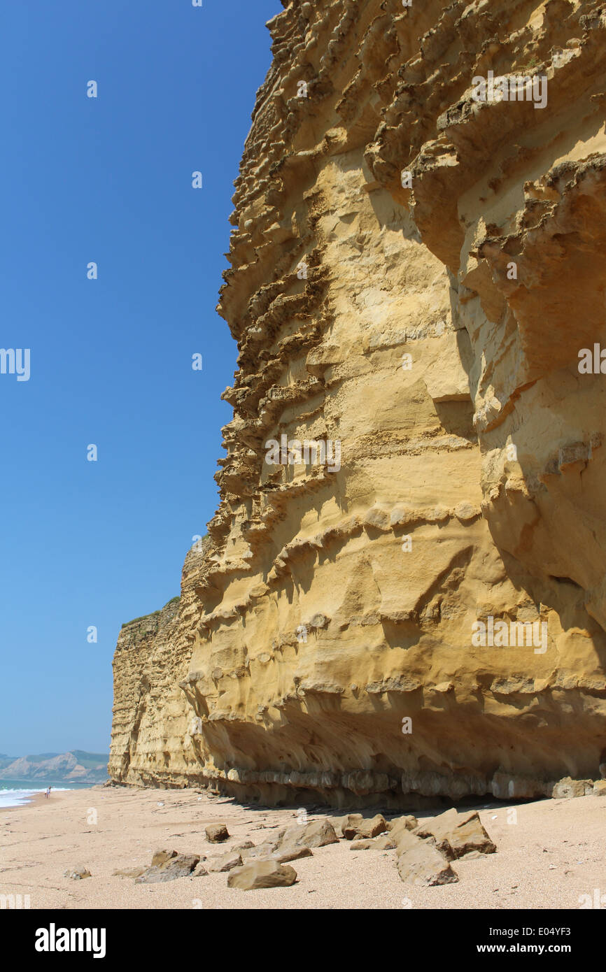 Scena costiere con spesso il cielo blu e la dura roccia, su una passeggiata costiera. Più terra visibile all'orizzonte. Combinazione di terra, mare e cielo Foto Stock