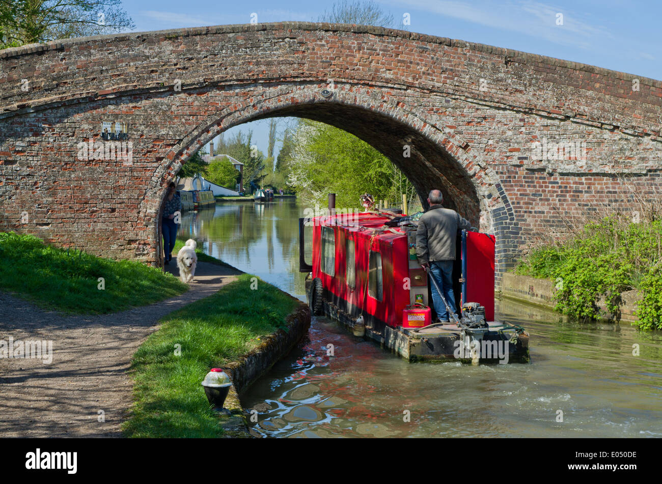 Una barca di manutenzione andare sotto un ponte sul canale di Oxford a Braunston, REGNO UNITO Foto Stock