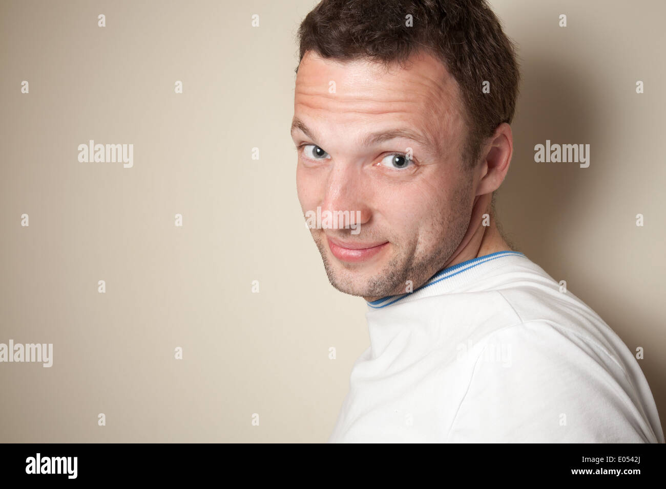 Sorridente giovane uomo caucasico in t-shirt bianco Foto Stock