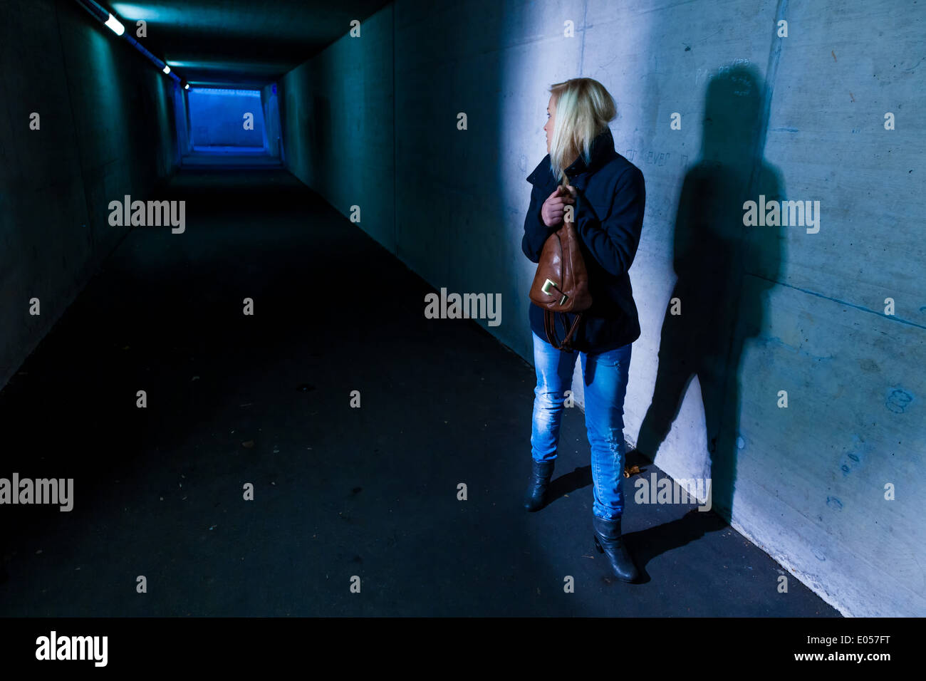 Una giovane donna in un sottopasso per pedoni è paura di fastidio e di attività criminale, Eine junge Frau in einer Unterfuehrun Foto Stock