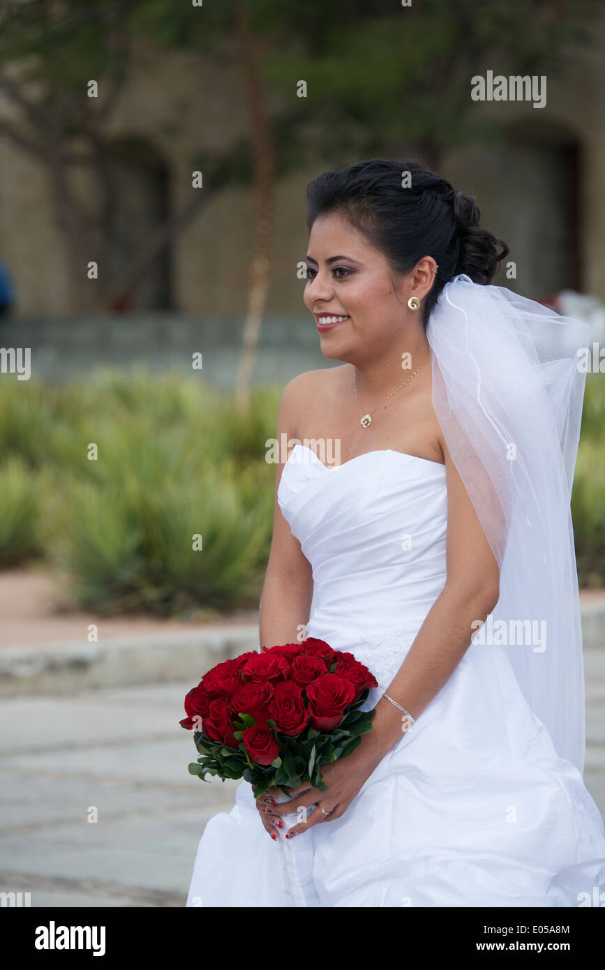 Sposa azienda posy di rose rosse al di fuori di chiesa di Santo Domingo città di Oaxaca Messico Foto Stock